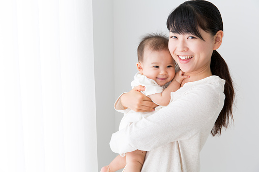 portrait of asian mother and baby in living room