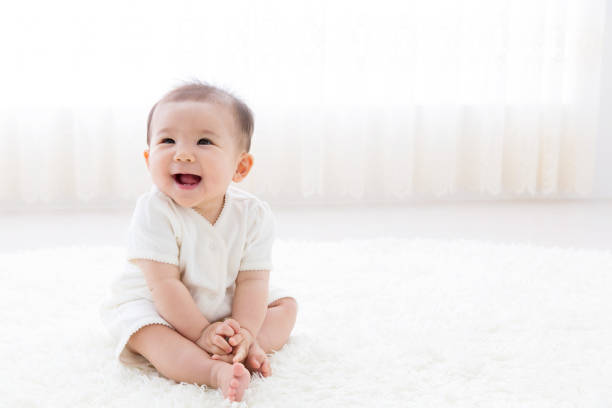 リビング ルームでのアジアの赤ちゃんの肖像画 - 日本人　笑顔 ストックフォトと画像