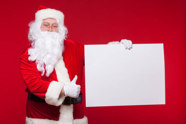 istock Santa Claus pointing in blank advertisement banner isolated on red background with copy space 864472872