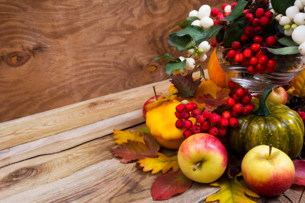 istock Fall enterpiece with rowan berries, green pumpkin, oak leaves and apples, copy space 864476484