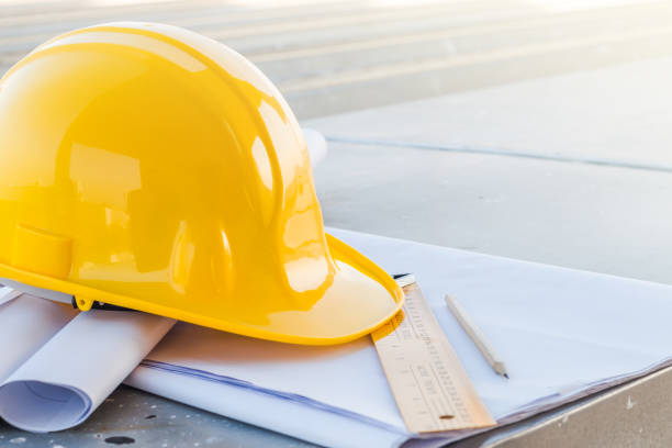 istock The yellow safety helmet and the blueprint at construction site 864482050