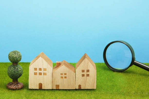 istock Houses and magnifying glass on green grass. 864482948