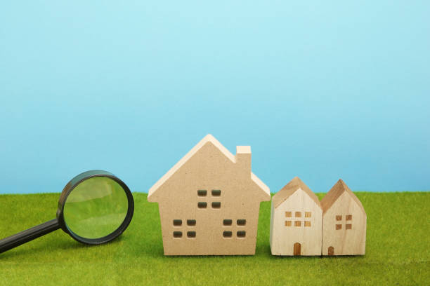 istock Houses and magnifying glass on green grass. 864482958