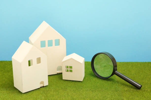 istock Houses and magnifying glass on green grass. 864482964