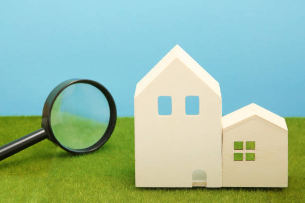 istock Houses and magnifying glass on green grass. 864482966