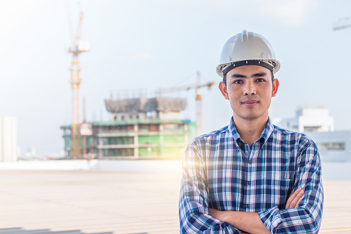 Portrait of architect wear white helmet safty on construction site with crane background