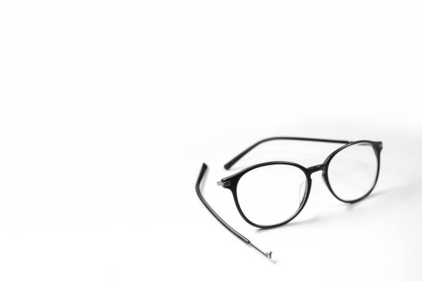 Old glasses on broken legs on white background