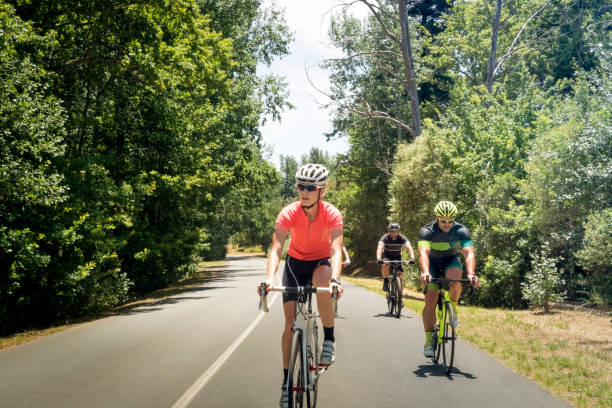 istock Cyclists riding bicycles on county road 864494734
