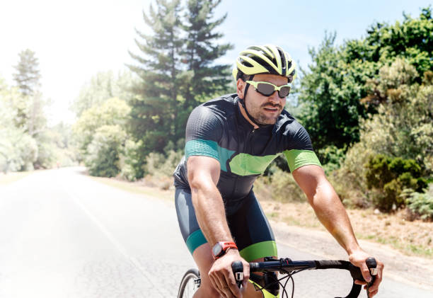 istock Fit young man riding bicycle on country road 864495730