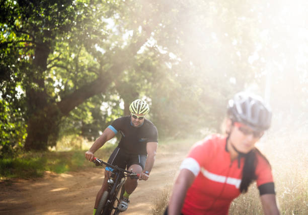 istock Sporty young man riding bicycle on dirt road 864496902