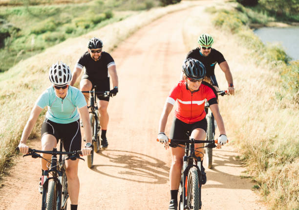 istock Determined friends riding bicycles on dirt road 864497132