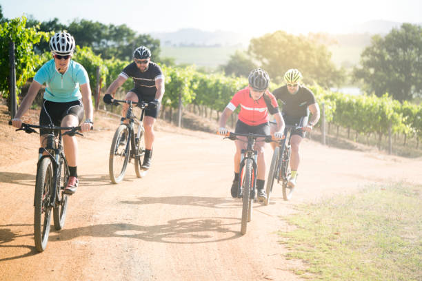 istock Determined friends riding bicycles on dirt road 864497244