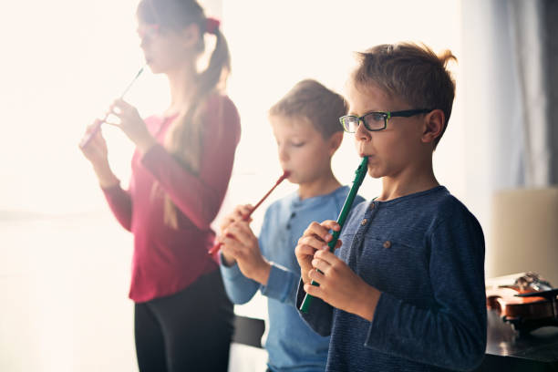 Kids playing flutes together in music class