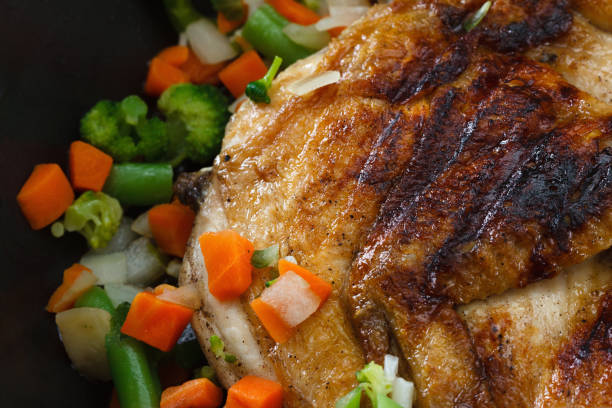 istock Whole grilled chicken with vegetables in a frying pan 864499438