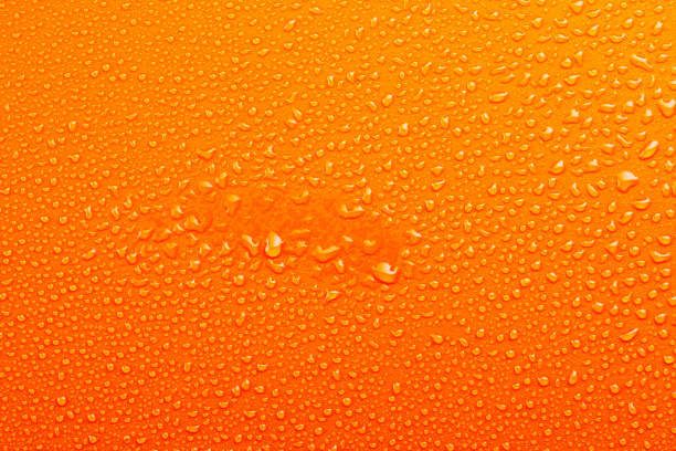 istock Water Drops On Orange Background Texture colorful waterdrop central spot 864499816