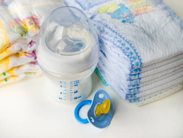 istock diapers,pacifier and bottle of milk close-up on light background 864501416