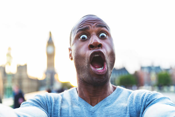 Handsome man making quirky faces and taking a selfie
