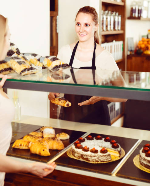 istock Bakery female worker with delicious pies and rolls on counter 864504888