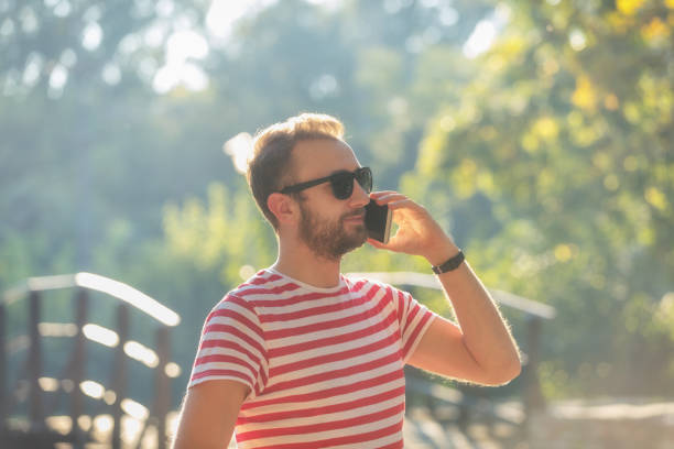 istock Young man talking on the phone in park. 864506164