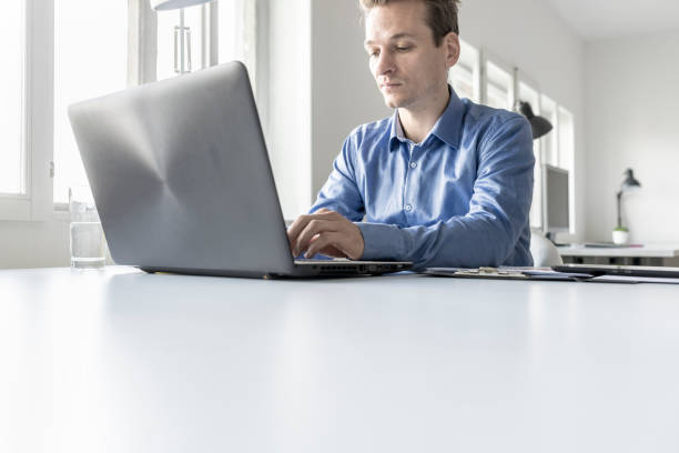 istock Businessman in office typing information on laptop computer 864506168