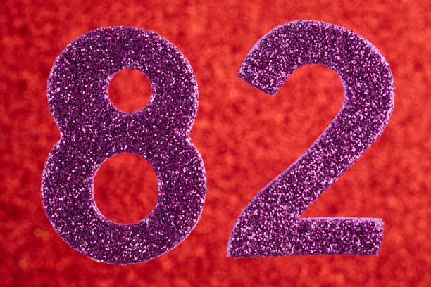 istock Number eighty-two purple color over a red background. Anniversary. 864506398
