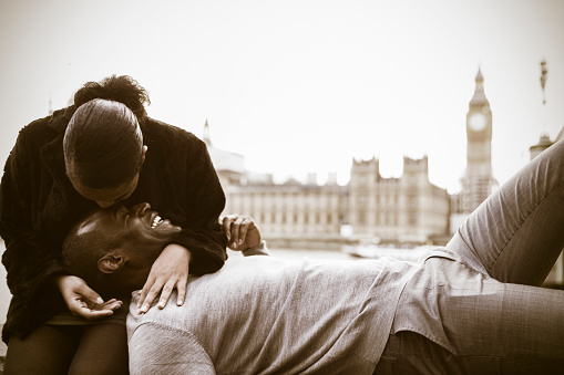 Young Couple visiting London and embracing each other near river Thames