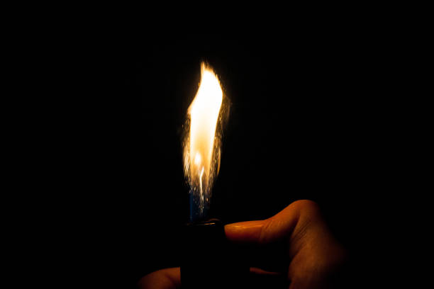 istock Close up view of real sparking light from lighter in dark black background 864509268