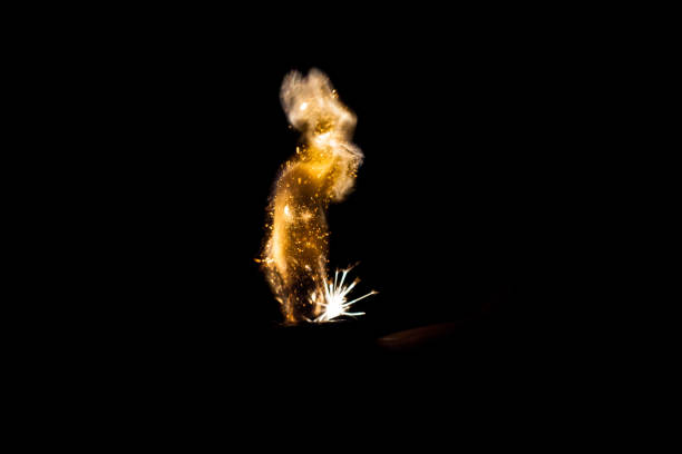 istock Close up view of real sparking light from lighter in dark black background 864509336