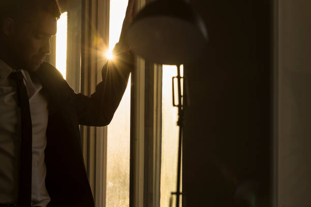 istock Businessman in a dark office with sunburst 864513318