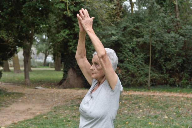 istock elderly woman practicing yoga outdoors 864513450
