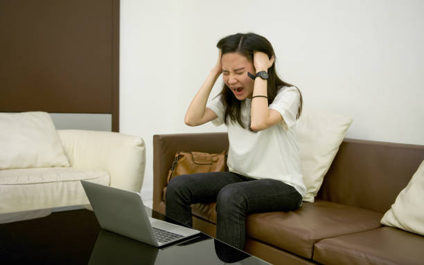 istock Stressed Asian woman using laptop at night, freelance working late 864513892