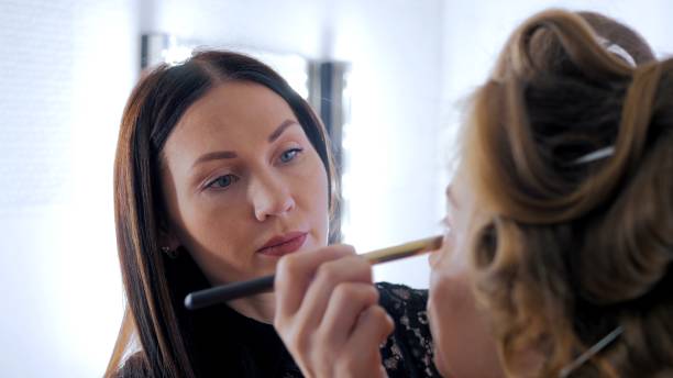 istock Professional make-up artist applying cream base eyeshadow primer to model eye 864516270