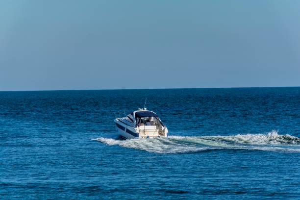 istock White cabin cruiser over blue water. 864517888