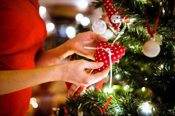 istock Unrecognizable young woman decorating Christmas tree. 864518916