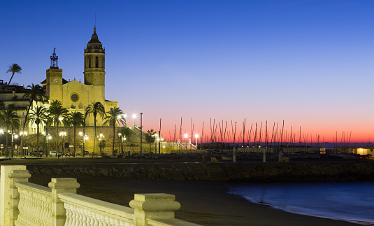 Sunset view of Sitges.  Church of Sant Bartomeu i Santa Tecla at beach. Catalonia