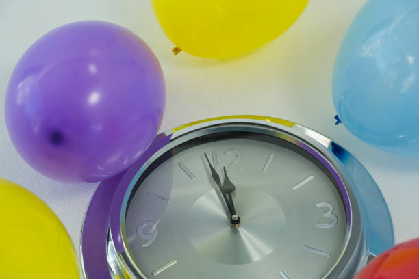 istock Balloons and clock hands reaching 12 o clock midnight 864523426