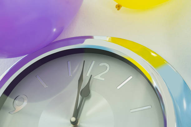 istock Balloons and clock hands reaching 12 o clock midnight 864523438