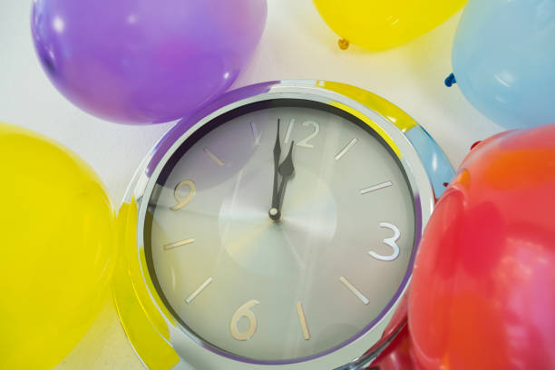 istock Balloons and clock hands reaching 12 o clock midnight 864523488