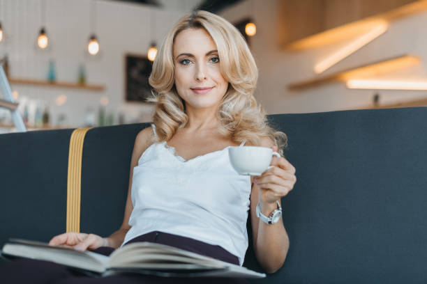 istock woman reading book in cafe 864525022