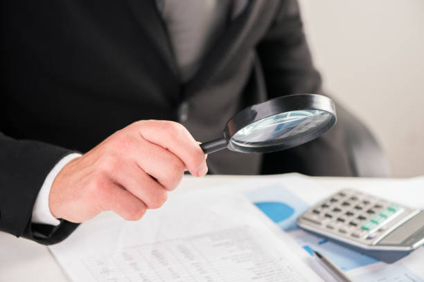 istock Businessman reading documents with magnifying glass concept for analyzing a finance 864525088