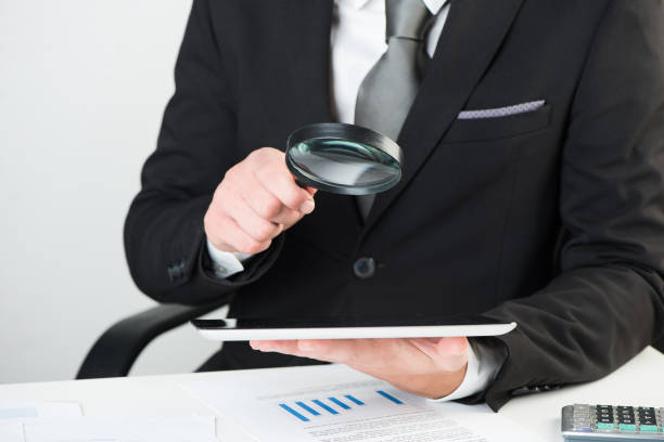istock Businessman reading documents with magnifying glass concept for analyzing a finance 864525878