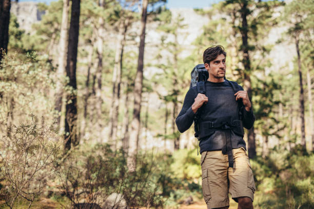 istock Man hiking in forest wearing a backpack 864527074