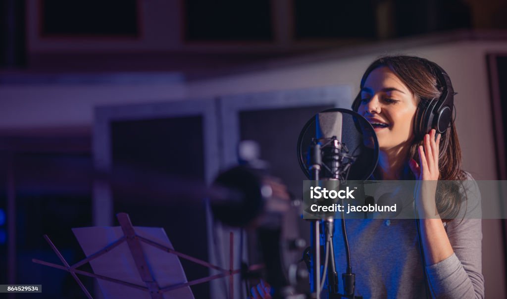 Playback singer recording album in the studio Female playback singer recording album in the professional studio. Woman singing a song in music recording studio. Singing Stock Photo