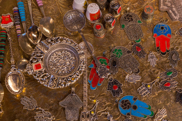 istock Souvenir spoons, amulets, thimbles and an ashtray lie on a brass tray. 864534310