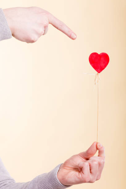 istock Male hand with little heart on stick. 864535766