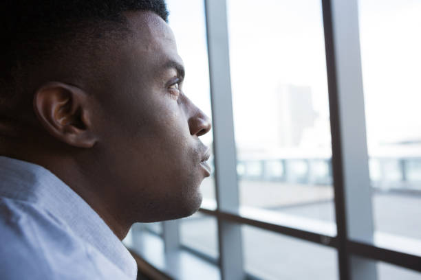 istock Man looking through window in futuristic office 864537696