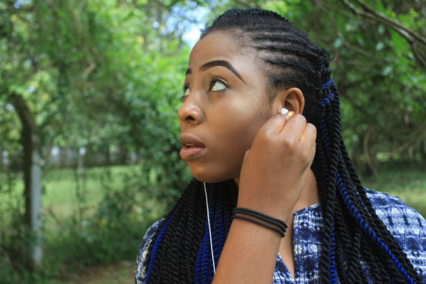 istock Young Lady fixes earphone from a Smartphone 864538594