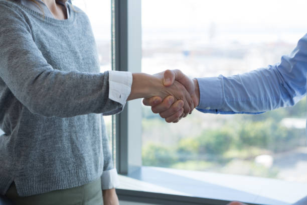 istock Male executive and female executive shaking hands with each other 864541136