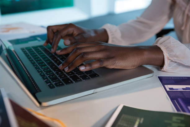 istock Female executive using laptop at desk in futuristic office 864542312