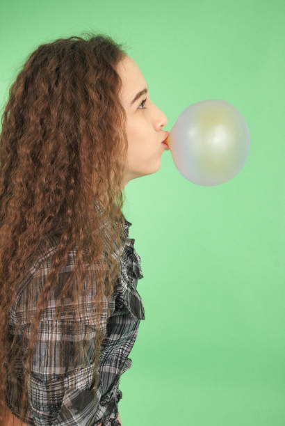 istock Girl blowing a bubblegum bubble 864543534